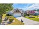 Beautifully landscaped front yard with green grass, shrubbery, and a long driveway to the garage at 174 Seville Dr., Murrells Inlet, SC 29576