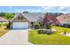 Charming brick home featuring a well-manicured lawn and a vibrant Japanese maple tree at 174 Seville Dr., Murrells Inlet, SC 29576