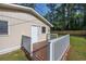 A rear wooden deck features white railings leading to a beige house with a white door at 2939 King St., Loris, SC 29569