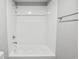 The bathroom features a tub and shower combination with white tiled walls and wood look flooring at 2939 King St., Loris, SC 29569