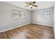 View of the bedroom, featuring wood flooring, base molding, and two bright windows at 2939 King St., Loris, SC 29569