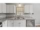 View of the kitchen with granite countertops, stainless steel appliances, and a large double sink at 2939 King St., Loris, SC 29569