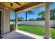 Inviting backyard patio with columns, wood ceiling, and view of the manicured lawn and privacy fence at 311 Las Olas Dr., Myrtle Beach, SC 29577