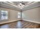 An empty bedroom with a trey ceiling, fan, two windows, and dark hardwood flooring at 311 Las Olas Dr., Myrtle Beach, SC 29577