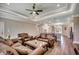 Spacious living area with tray ceiling, fan, wood floors, and open layout to the kitchen for easy entertaining at 311 Las Olas Dr., Myrtle Beach, SC 29577