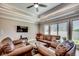 Inviting living room features tray ceiling, fan, wood floors, and leather sofas creating a warm atmosphere at 311 Las Olas Dr., Myrtle Beach, SC 29577