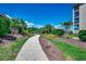 Beautifully landscaped walkway winding through lush tropical plants and trees on a bright, sunny day at 311 Las Olas Dr., Myrtle Beach, SC 29577