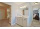 Bathroom vanity area with white cabinets, framed mirror, and tiled floors at 4017 Chalmers Ct., Myrtle Beach, SC 29579