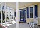 Charming front porch with rocking chairs and a beautifully designed blue front door, offering curb appeal at 4017 Chalmers Ct., Myrtle Beach, SC 29579