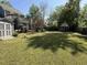 Large backyard featuring green grass, mature trees, and a charming shed, perfect for outdoor activities at 7 Pine Valley Ln., Surfside Beach, SC 29575
