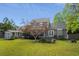 Rear exterior of home with a fenced yard, shed, and a chimney, with a tree in the lawn at 7 Pine Valley Ln., Surfside Beach, SC 29575