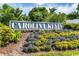 Welcoming Carolina Keyes entrance sign surrounded by colorful flowers and lush greenery enhances curb appeal at 901-9 West Port Dr. # 907, North Myrtle Beach, SC 29582