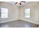 The airy bedroom has wood-look floors, a ceiling fan, and two windows that let in natural light at 932 Jackline Place # 103, Murrells Inlet, SC 29576