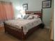 Cozy bedroom with a wooden bed frame and soft lighting at 1000 Ray Costin Way # 108, Murrells Inlet, SC 29576
