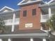 Exterior view of Villas 100 showing signage, multiple balconies, and brick architectural details at 1000 Ray Costin Way # 108, Murrells Inlet, SC 29576