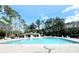 Large community pool surrounded by ample seating, trees, and a cabana area at 103 Club Circle # 1-1, Pawleys Island, SC 29585
