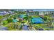 Aerial view of tennis courts, a pool, and green spaces surrounded by condo buildings in a beautiful community at 112 Spartina Ct. # 26, Pawleys Island, SC 29585