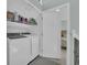 Modern laundry area with a white washer and dryer, as well as shelving for supplies, right off the bedroom at 112 Spartina Ct. # 26, Pawleys Island, SC 29585