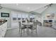 Open-concept living room with large windows, vaulted ceiling, and white wooden dining table and chairs at 112 Spartina Ct. # 26, Pawleys Island, SC 29585