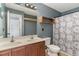 Bathroom featuring double sink vanity, wooden shelves and patterned shower curtain at 113 Winding Path Dr., Loris, SC 29569