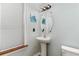 Half bathroom with pedestal sink and window with blinds, accented by light blue walls at 113 Winding Path Dr., Loris, SC 29569