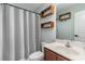 Bright bathroom with white sink, wooden shelves and patterned shower curtain at 113 Winding Path Dr., Loris, SC 29569