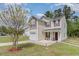 Charming two-story home featuring a covered entryway, attached garage, and well-maintained landscaping at 113 Winding Path Dr., Loris, SC 29569
