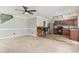 Spacious living room adjacent to a kitchen area with breakfast bar, ceiling fan, and neutral paint at 113 Winding Path Dr., Loris, SC 29569
