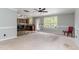 Open-concept living room with a kitchen, ceiling fan, carpet, and large windows for ample natural light at 113 Winding Path Dr., Loris, SC 29569