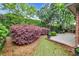 Serene backyard featuring a brick patio, lush landscaping, and mature trees providing privacy at 115 Harbor Club Dr. # 4A, Pawleys Island, SC 29585
