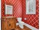 Stylish half bath features a wood vanity, unique mirror, and decorative wallpaper at 115 Harbor Club Dr. # 4A, Pawleys Island, SC 29585