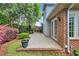 Brick patio with garden, shrubbery, and a partial view of the exterior with French doors at 115 Harbor Club Dr. # 4A, Pawleys Island, SC 29585