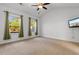 Bright, carpeted bedroom with a ceiling fan, windows dressed with drapes, and a television at 120 Carolina Crossing Blvd., Little River, SC 29566