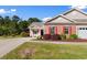 Beautifully landscaped front yard featuring a well-maintained lawn, mature plantings, and a charming covered porch at 120 Carolina Crossing Blvd., Little River, SC 29566