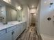Bathroom featuring double sink vanity, white subway tile shower, and a large mirror with modern lighting at 1209 Lady Bird Way, North Myrtle Beach, SC 29582