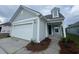 Charming, light-grey home featuring a white garage door, craftsman accents, and a welcoming covered entryway at 1209 Lady Bird Way, North Myrtle Beach, SC 29582