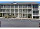 Three-story condo building with white doors, windows, and railings, offering a charming coastal living experience at 1450 Blue Tree Ct. # I, Myrtle Beach, SC 29588