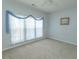 Bright bedroom with a ceiling fan, carpet flooring, and window with sheer curtains at 1512 Hallborough Dr., Surfside Beach, SC 29575