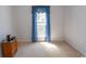 Cozy bedroom with light carpet, white walls, and a bright window framed by blue curtains at 1512 Hallborough Dr., Surfside Beach, SC 29575