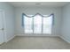 A bright bedroom featuring neutral walls, plush carpet, and a well-lit window with elegant curtains at 1512 Hallborough Dr., Surfside Beach, SC 29575