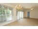 Bright living room area with a chandelier, sliding glass doors, and wood-look flooring at 1512 Hallborough Dr., Surfside Beach, SC 29575