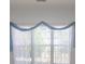Sheer white curtains with soft blue drapery hang over a window at 1512 Hallborough Dr., Surfside Beach, SC 29575