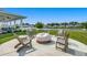 Relaxing community fire pit area with Adirondack chairs overlooking the lake and homes at 168 Zostera Dr., Little River, SC 29566