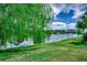 Scenic view of a serene pond with lush green landscaping and blue sky with fluffy clouds at 168 Zostera Dr., Little River, SC 29566