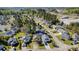Aerial view capturing the neighborhood with homes, driveways, and mature trees, set against a commercial backdrop at 174 Sussex Ct., Longs, SC 29568