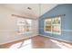 Cozy dining area featuring a modern chandelier, large windows, and bright blue accent wall at 174 Sussex Ct., Longs, SC 29568
