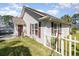 Home exterior featuring well-maintained landscaping and white picket fence with a brown door and window shutters at 174 Sussex Ct., Longs, SC 29568