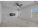 Carpeted bedroom with modern fireplace, ceiling fan, and plantation shutters at 181 Saddle St, Conway, SC 29527