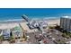 An aerial view highlighting the pier, beachfront buildings, and nearby parking in a bustling coastal area at 1880 Auburn Ln. # 27 A, Surfside Beach, SC 29575
