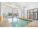 Indoor pool area featuring a tiled pool deck, clear blue water, and access to the restroom and the outdoor pool at 2001 S Ocean Blvd. # 1303, Myrtle Beach, SC 29577